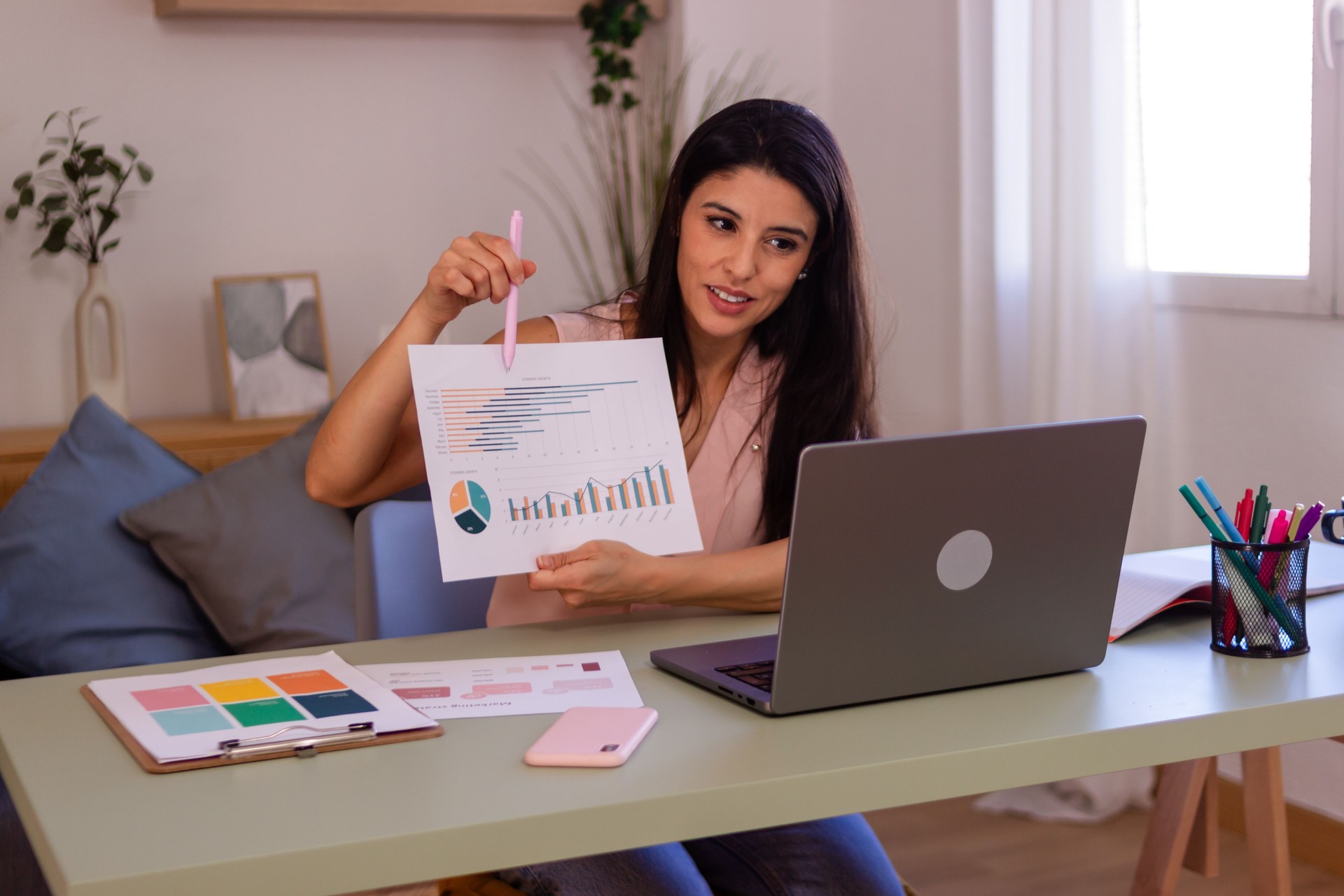 Businesswoman presenting business report using laptop having video conference at home office